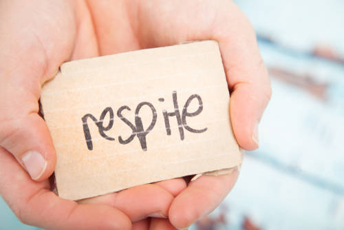 Hands holding card that says respite